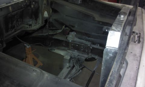 1967 Ford F-100 - The engine bay of a 1967 Ford F-100 shows the radiator and chassis components, supported by jack stands.