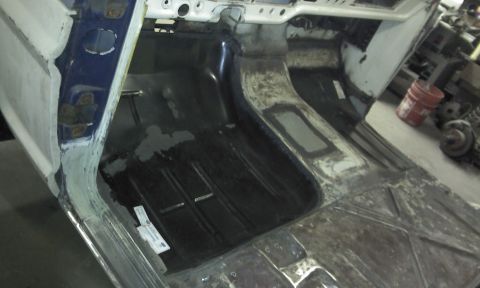1967 Ford F-100 - The interior floor and transmission tunnel of a truck are shown during a repair process, with visible rust and bodywork.