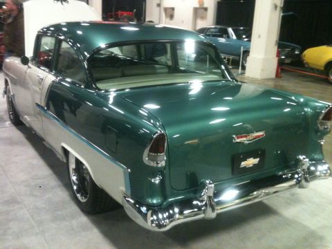2004 Ford Crown Victoria - A classic 1955 Chevrolet Bel Air is displayed indoors, showing its distinctive two-tone paint scheme and chrome accents.