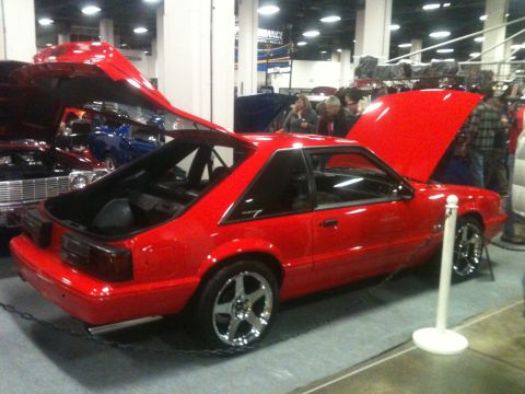 2004 Ford Crown Victoria - A red 1987 Ford Mustang coupe is displayed with its hoods open at a car show.