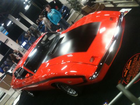 2004 Ford Crown Victoria - Red sports car on display at an auto show, with a sign that says "KING COBRA".
