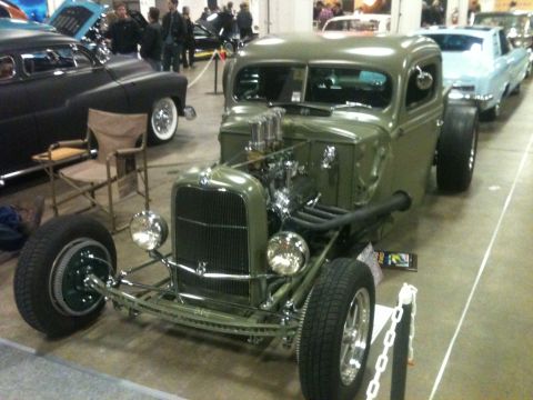 2004 Ford Crown Victoria - A custom hot rod pickup truck is displayed indoors, with other vehicles visible in the background.