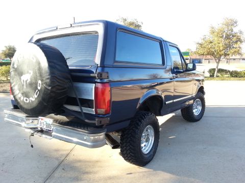 1995 Ford Bronco - This lifted 1995 Ford Bronco is shown from the rear, a spare tire mounted on the tailgate.