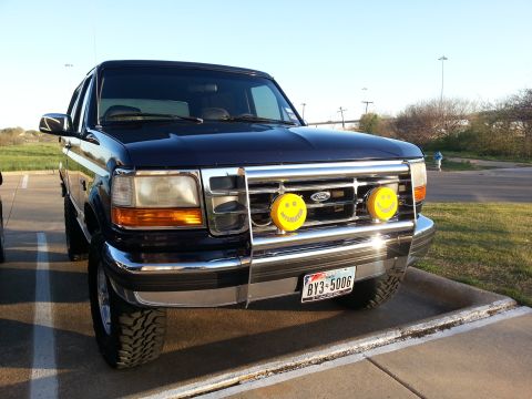 1995 Ford Bronco - This 1995 Ford Bronco is parked outside on a sunny day, showing its front grille and bumper.