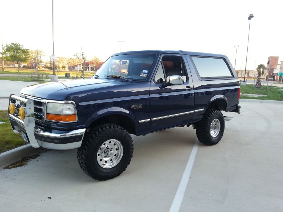 Dark blue 1995 Ford Bronco with lifted suspension and off-road tires