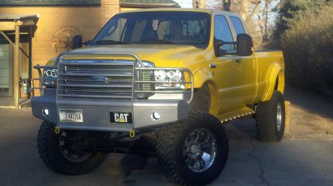 2005 Ford F-350 - This lifted yellow Ford Super Duty pickup truck is equipped with a heavy-duty front bumper and large off-road tires.