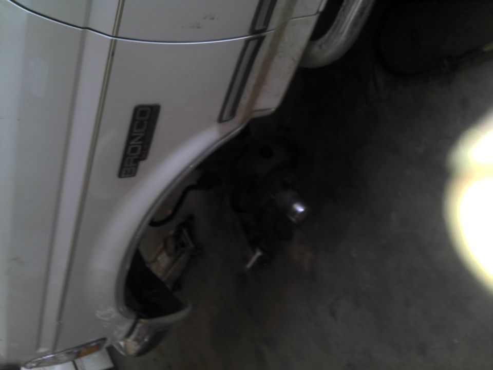 White Ford Bronco fender with a black emblem and chrome trim