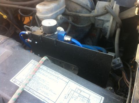 1989 Ford Bronco - Aftermarket air compressor installed in the engine bay, with a visible Ford label on the cover.