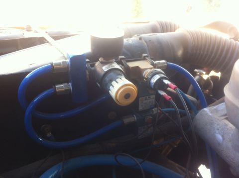 1989 Ford Bronco - Detail of engine bay components, including blue tubing and electrical connections.