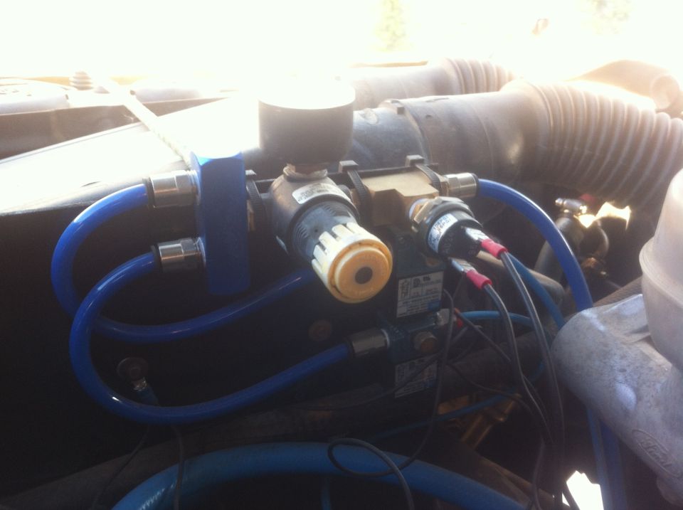 Close-up of engine compartment with blue hoses and various valves and sensors