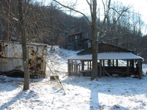 1992 Ford Bronco - A snowy scene features a dilapidated trailer and an open-sided wooden shelter, with a "SUPERMOTORS" logo visible in the lower right corner.