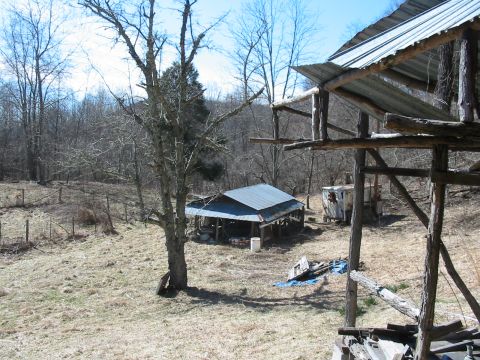 1992 Ford Bronco - A rustic outdoor scene dilapidated wooden shelters and surrounding trees, with a 'Supermotors.net' watermark visible.