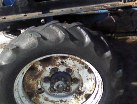 2000 Chevrolet Tahoe - A close-up of a tractor's tire and wheel assembly, showing wear and rust.