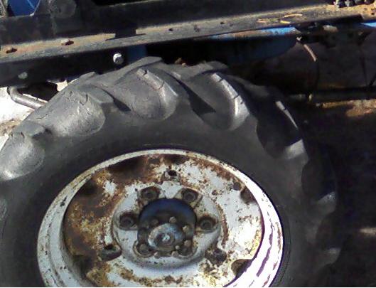 Tractor tire with white rusty wheel, close-up side view