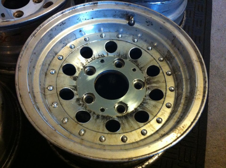 Polished aluminum truck wheel with bolt-ring detail lying face-up on a mat