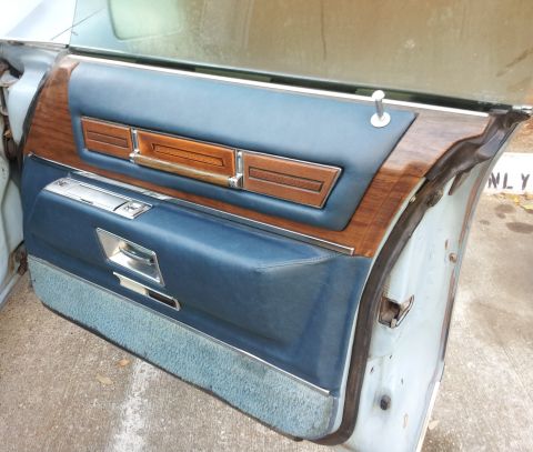 2008 Subaru Legacy - Close-up of a vintage car's interior door panel, blue upholstery and wood trim.