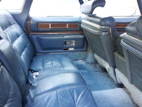 2008 Subaru Legacy - The interior of a car shows blue leather seats and door panels with wood accents.