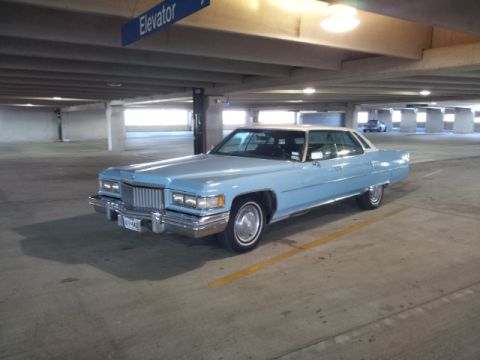 2008 Subaru Legacy - A classic Cadillac coupe with a white vinyl roof is parked in a concrete parking structure.