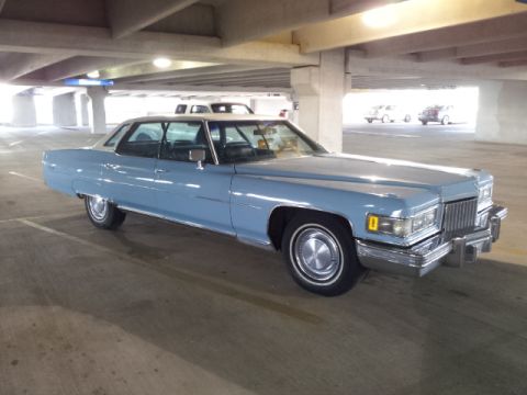 2008 Subaru Legacy - A light blue 1974 Cadillac sedan is parked in a concrete parking garage.
