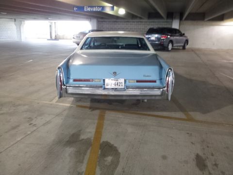 2008 Subaru Legacy - A light blue Cadillac sedan is parked in a garage, showing its rear end and license plate.