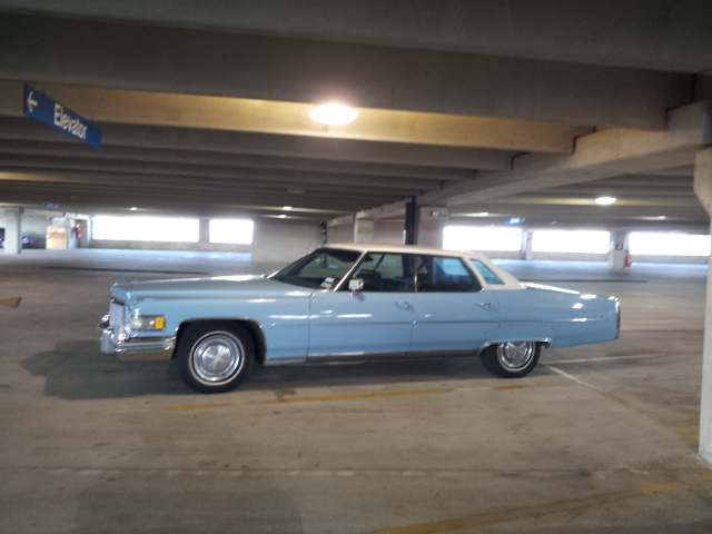 Light blue 1974 Cadillac Sedan de Ville parked in a parking garage