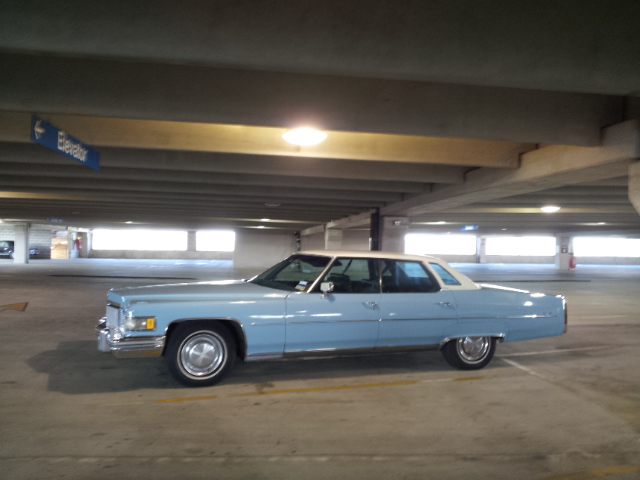 light blue sedan with white roof parked in a parking garage