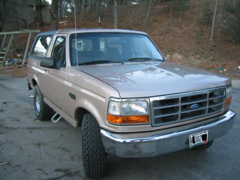 1996 Ford Bronco - This 1996 Ford Bronco is parked on a dirt lot with trees and a playset visible.