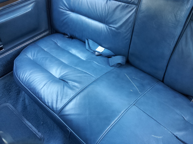 Blue leather rear seat with seatbelt and scratches