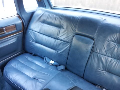 2008 Subaru Legacy - The interior of a car features tufted blue leather seats and a seatbelt.