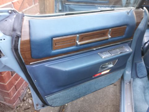 2008 Subaru Legacy - Close-up of the blue interior door panel with wood grain trim and chrome handle.