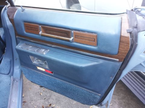 2008 Subaru Legacy - Close-up of a car's interior door panel, showing blue upholstery and wood grain accents.