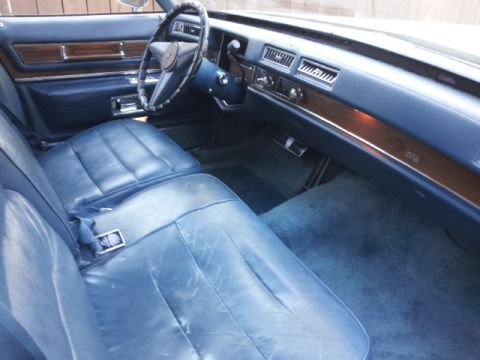 2008 Subaru Legacy - The interior of a classic car features blue leather seats and wood trim on the dashboard.