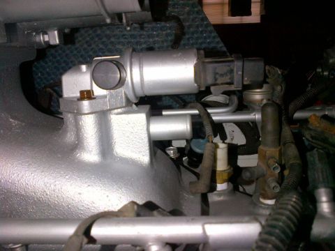 1994 Ford Bronco - Close-up view of an engine component, possibly an EGR valve, with associated tubing and wiring.