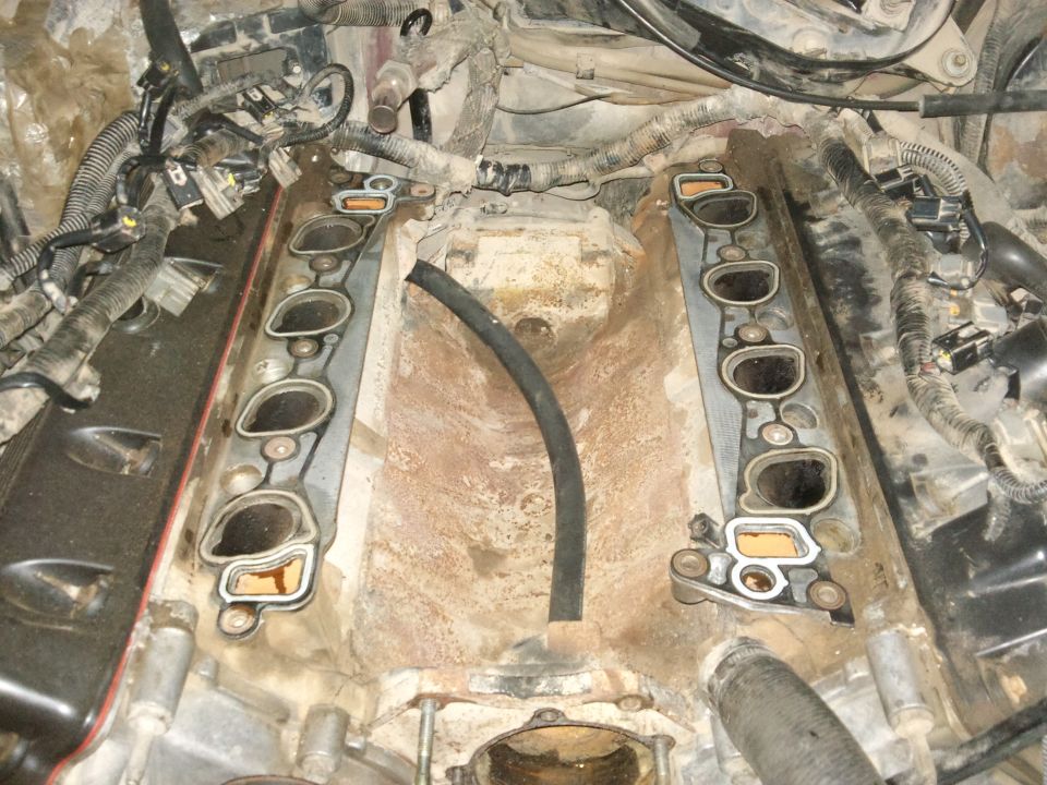 Engine intake manifold with gaskets removed, showing ports and wiring harness