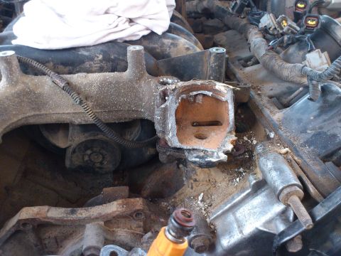 1998 Ford Crown Victoria - The intake manifold shows significant damage and wear, with visible debris and a fuel injector in the foreground.