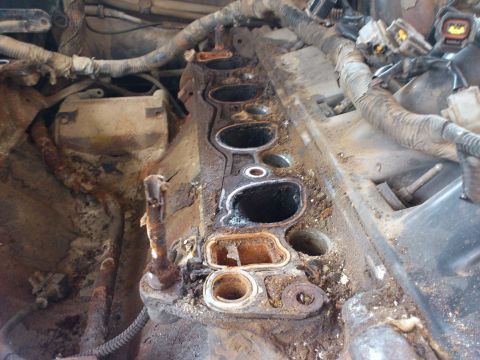 1998 Ford Crown Victoria - Close-up view of a heavily corroded engine intake manifold, showing signs of wear and tear.
