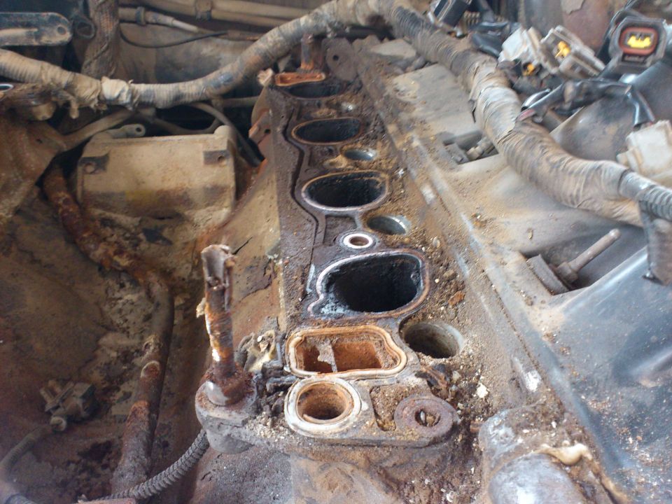 Engine intake manifold with corroded bolts and gasket residue