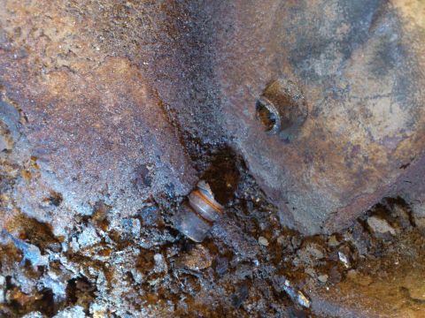 1998 Ford Crown Victoria - This image shows a close-up of heavily rusted metal with a bolt head visible.