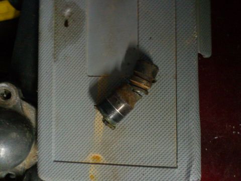 1998 Ford Crown Victoria - A close-up view of a corroded metal component with visible banding and a broken section.
