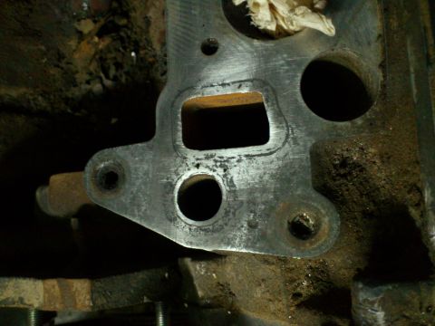 1998 Ford Crown Victoria - Close-up of a metal engine part, likely an intake manifold gasket, showing wear and grime.