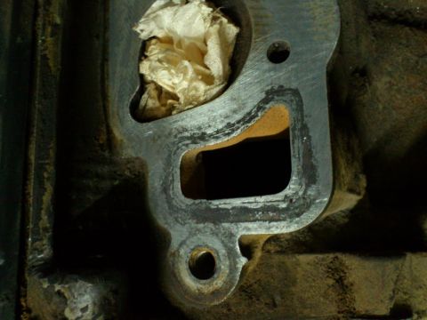 1998 Ford Crown Victoria - Close-up of an intake manifold gasket surface, with a hole plugged with cloth.