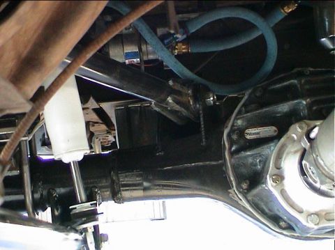 1979 Ford Bronco - Close-up view of a rear axle assembly, a "Strange Engineering" data plate and blue hydraulic lines.
