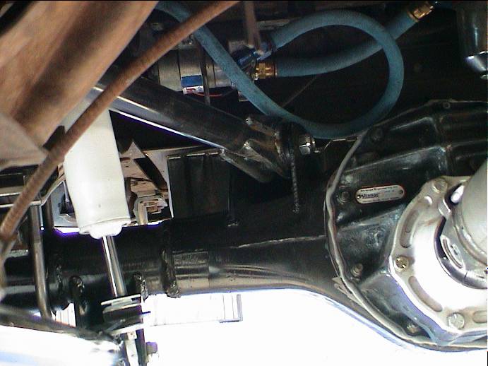 Undercarriage view of rear differential, driveshaft, and white shock absorber