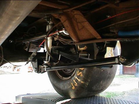 1979 Ford Bronco - Close-up view of the rear axle, suspension components, and a large tire on a vehicle.