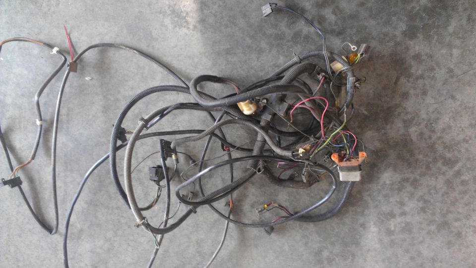 Tangled automotive wiring harness with connectors and black protective loom
