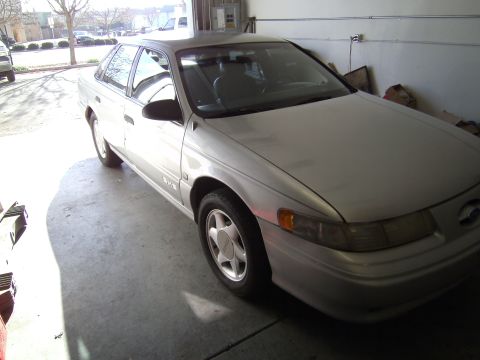 1992 Ford Taurus - Silver 1992 Ford Taurus sedan in a garage, showing its front 3/4 view with the driver's side visible.
