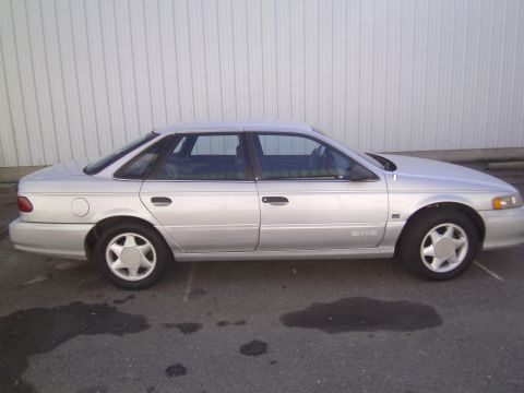1992 Ford Taurus - Side view of a silver 1992 Ford Taurus sedan parked outdoors.