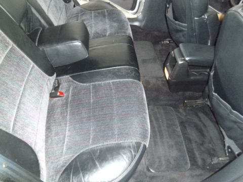 1992 Ford Taurus - The interior of a car shows patterned seats and a center console with cup holders.