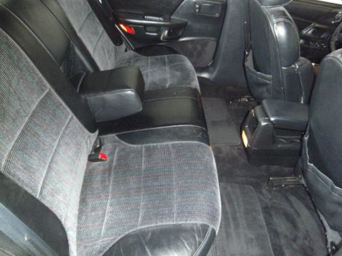 1992 Ford Taurus - The rear interior of a vehicle shows patterned fabric seats and leather accents.