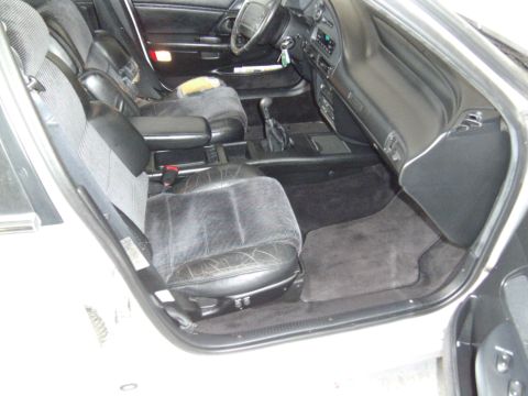 1992 Ford Taurus - The interior of the car shows worn leather seats and a dark dashboard with a gear shifter visible.